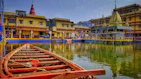 a row boat sitting on top of a lake next to a yellow building