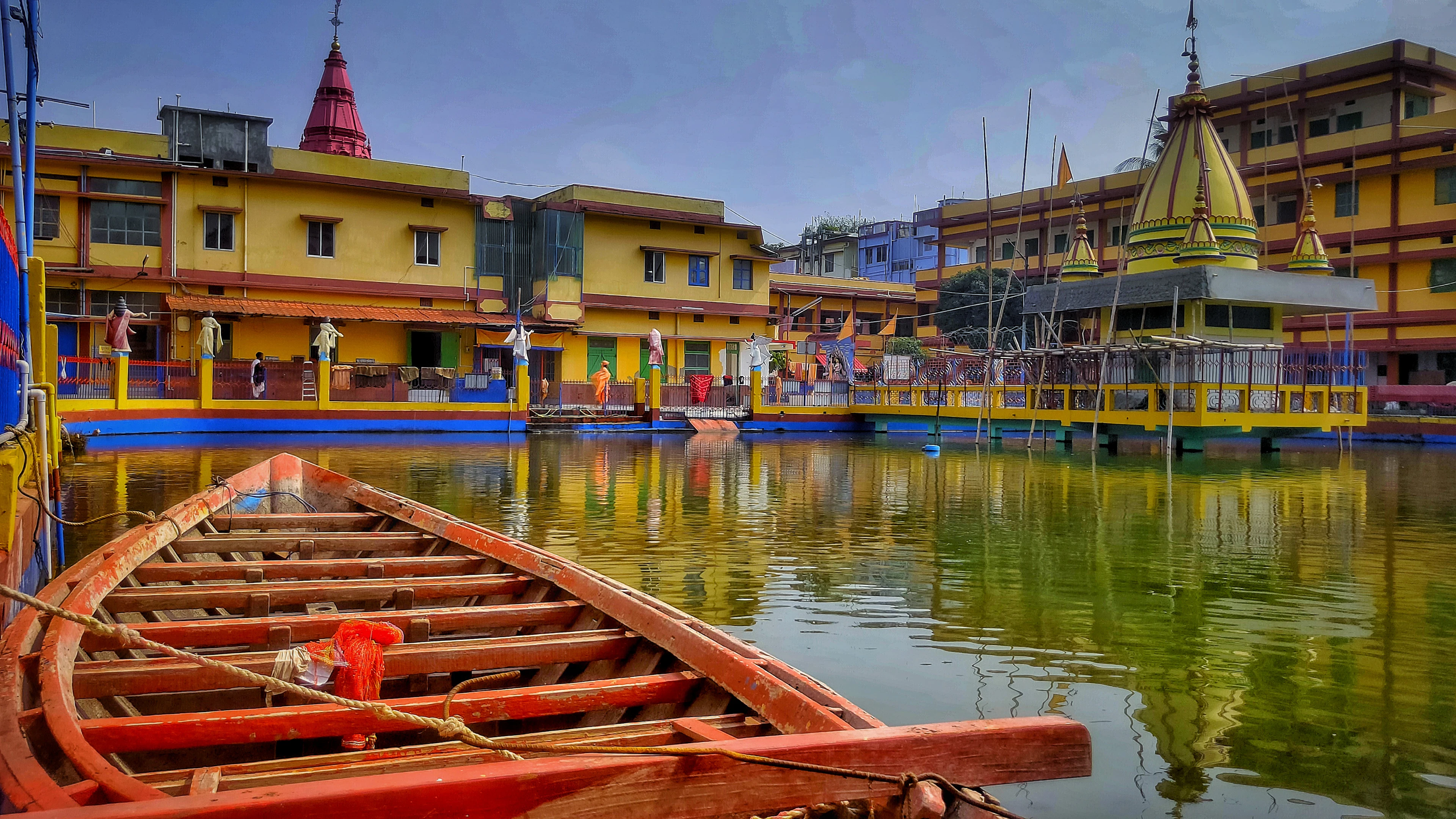 A rowing boat beside a palace on a lake in Tripura
