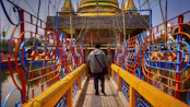 a person walking across a bridge over a body of water
