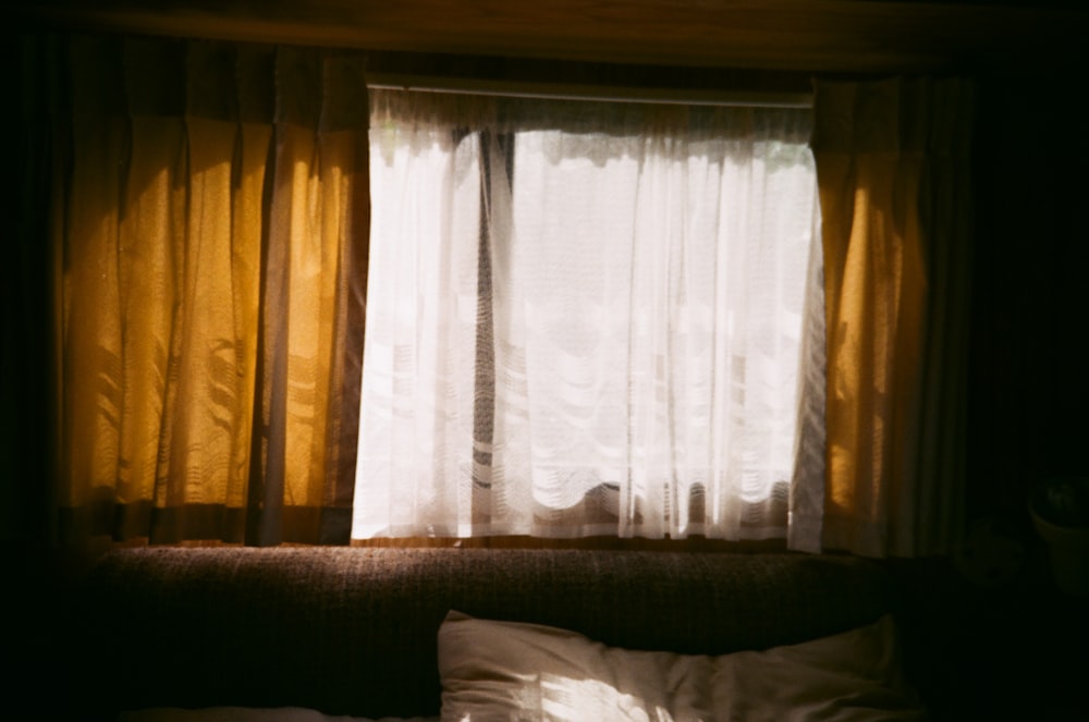 a bed sitting under a window next to a window