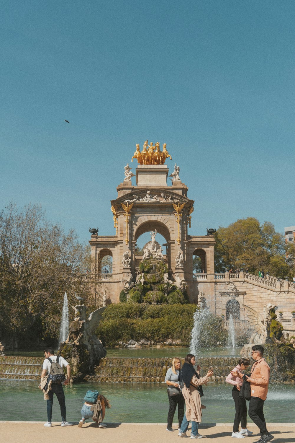 a group of people standing in front of a fountain