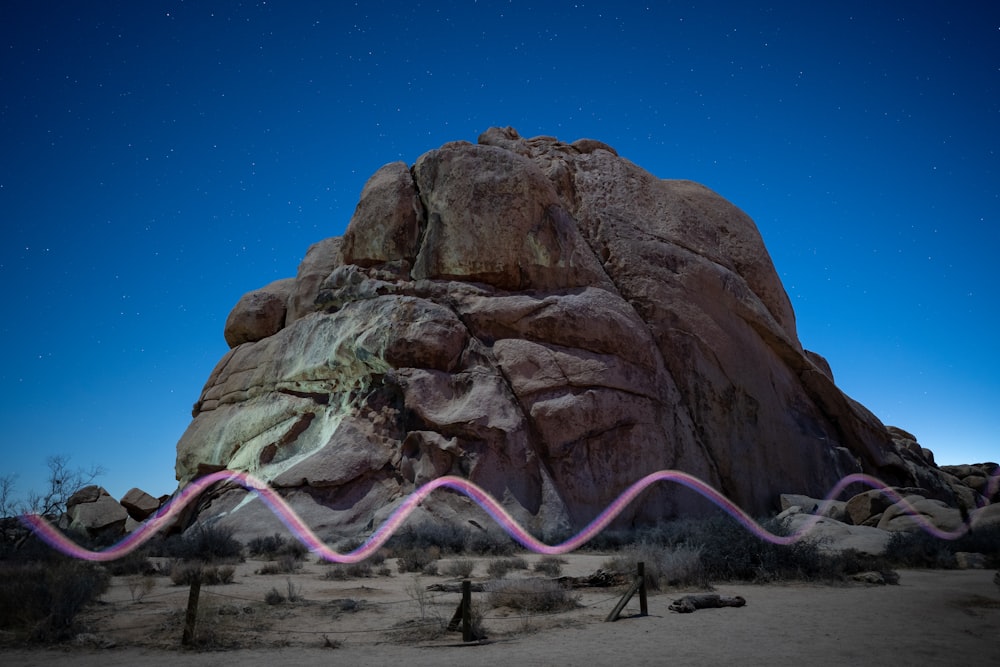 a large rock with a pink line in front of it