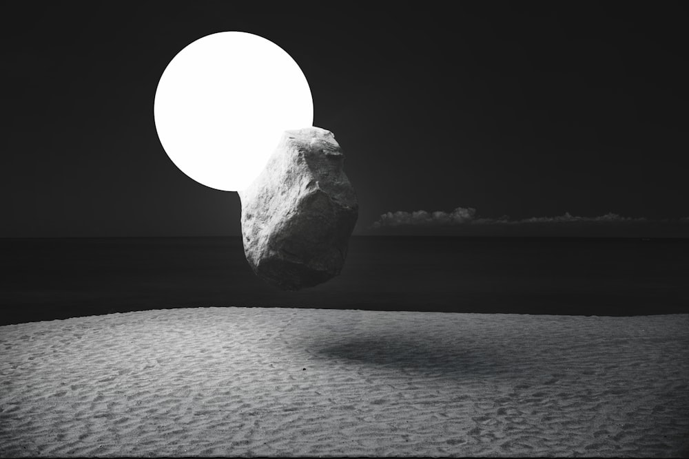 a large rock sitting on top of a sandy beach