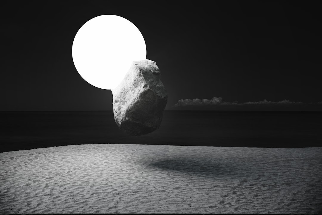 a large rock sitting on top of a sandy beach,