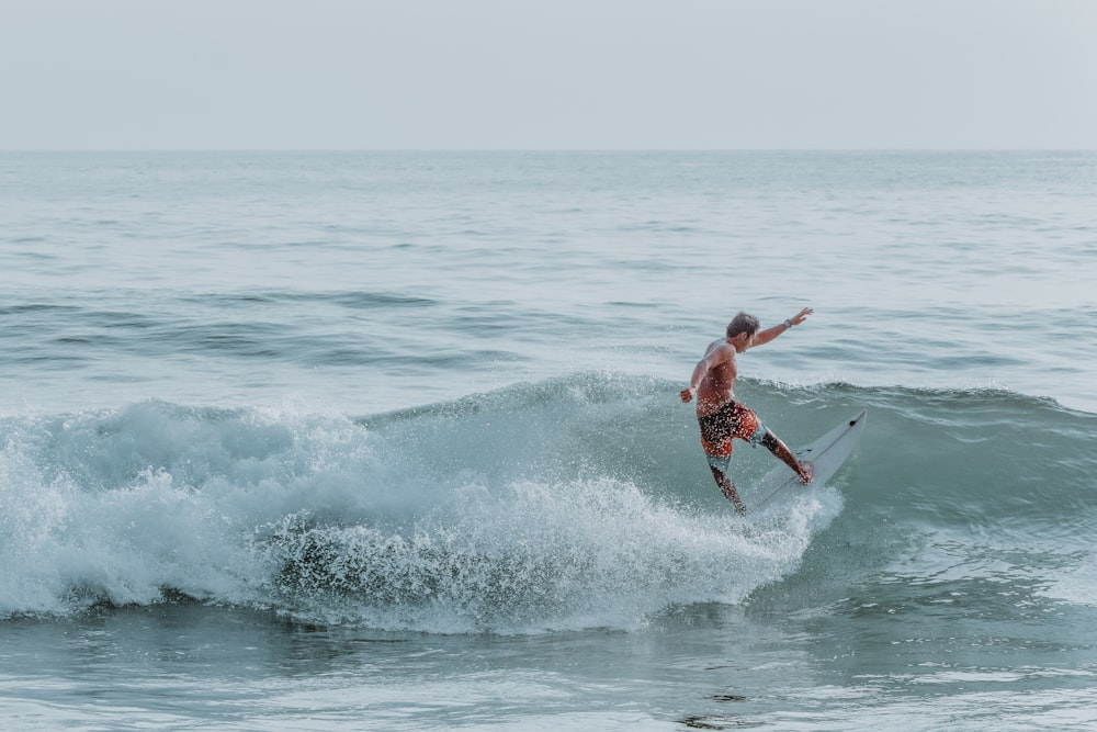 a man riding a wave on top of a surfboard