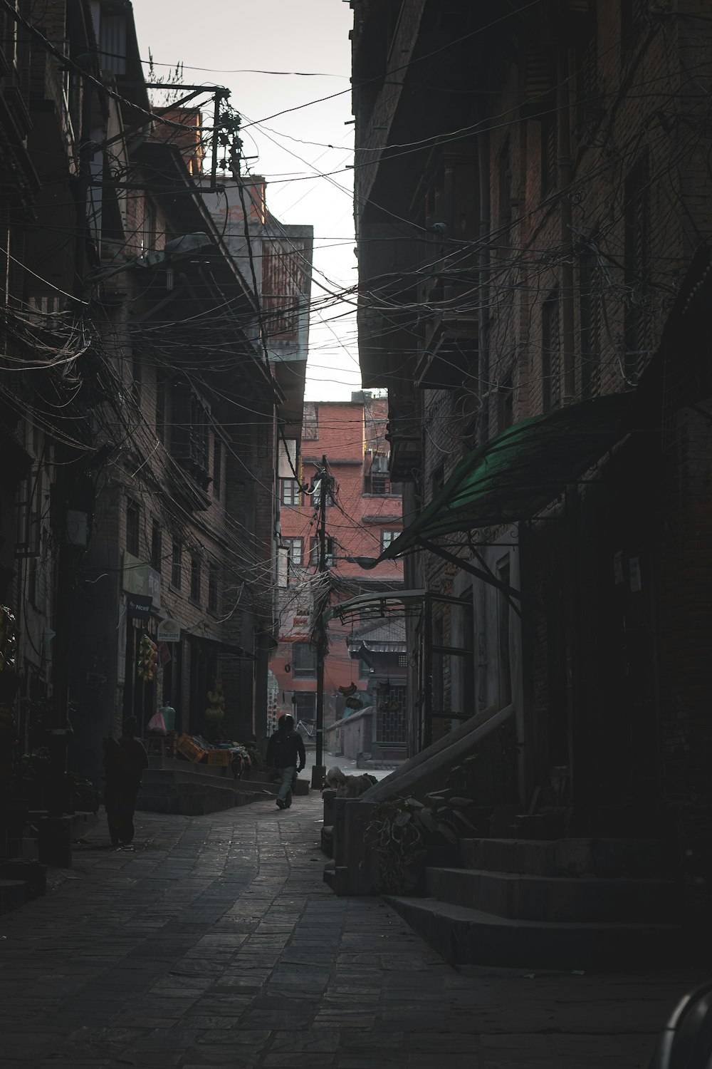 a person walking down a street next to tall buildings