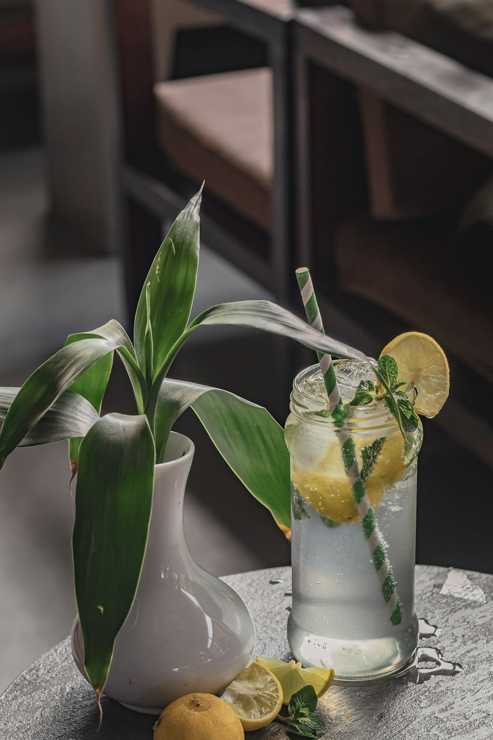 a glass of lemonade and a vase of lemons on a table