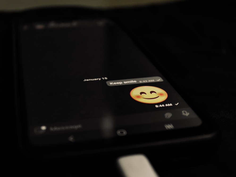 a cell phone with a smiley face on the screen
