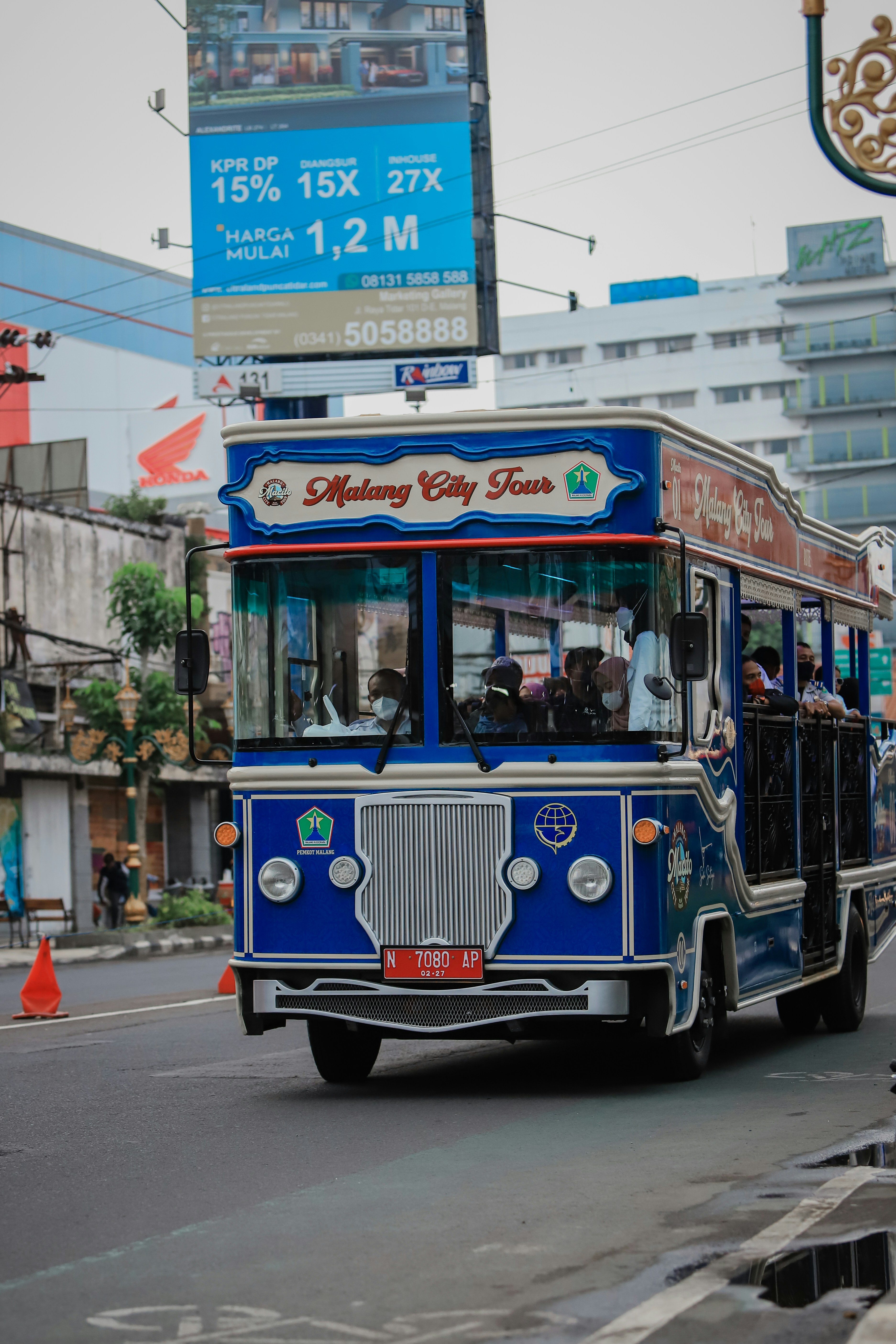 a blue bus driving down a street next to tall buildings