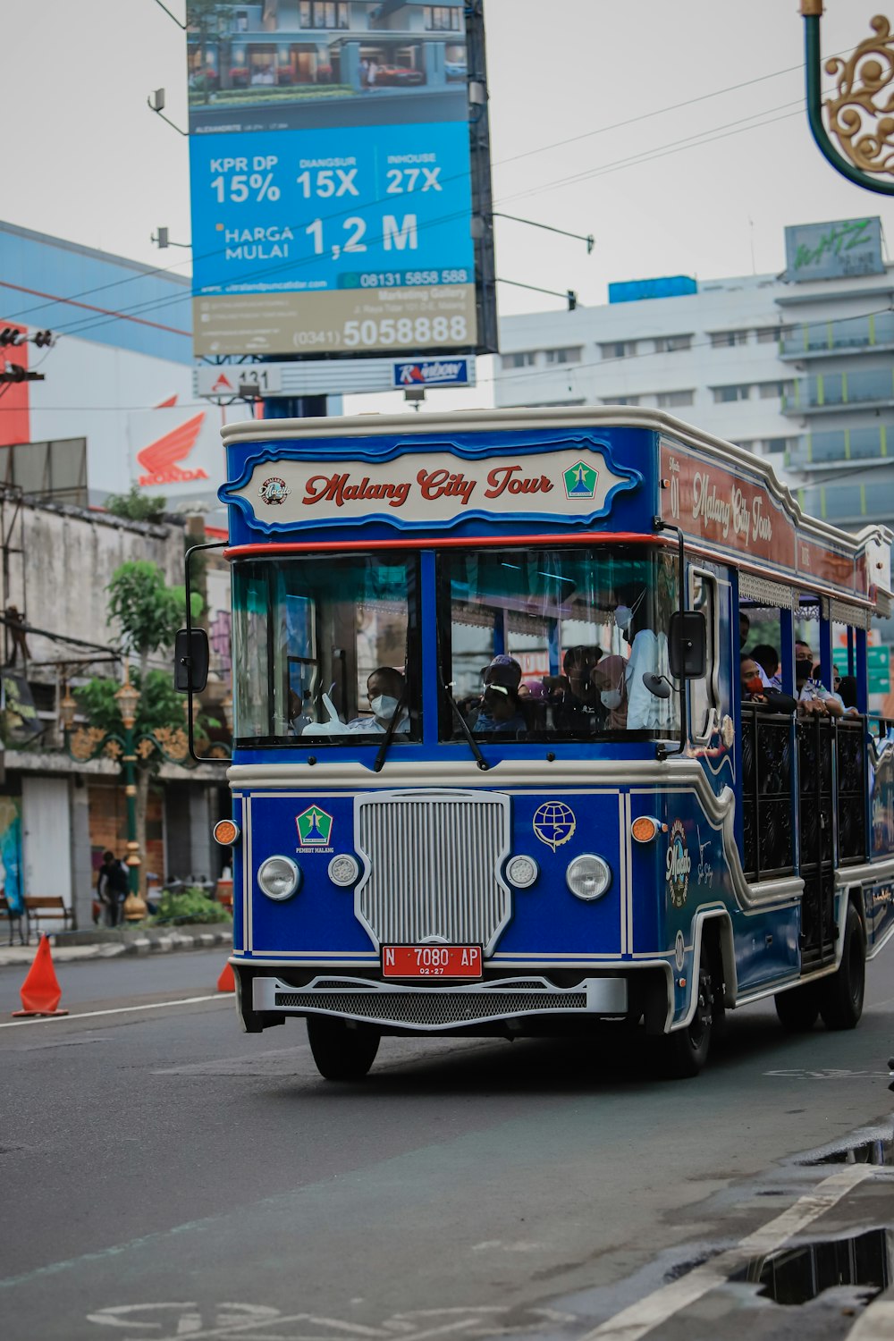 a blue bus driving down a street next to tall buildings