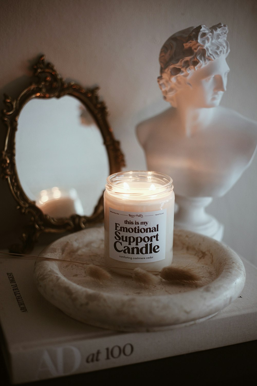 a candle sitting on top of a table next to a mirror