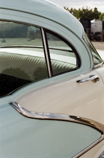 A vintage car with a modern twist, showcasing a glossy deep blue paint job and chrome details under bright sunlight