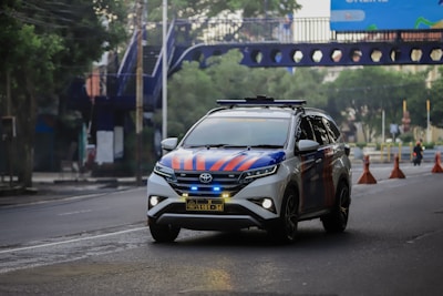 a car driving down a street with a blue and orange design on it
