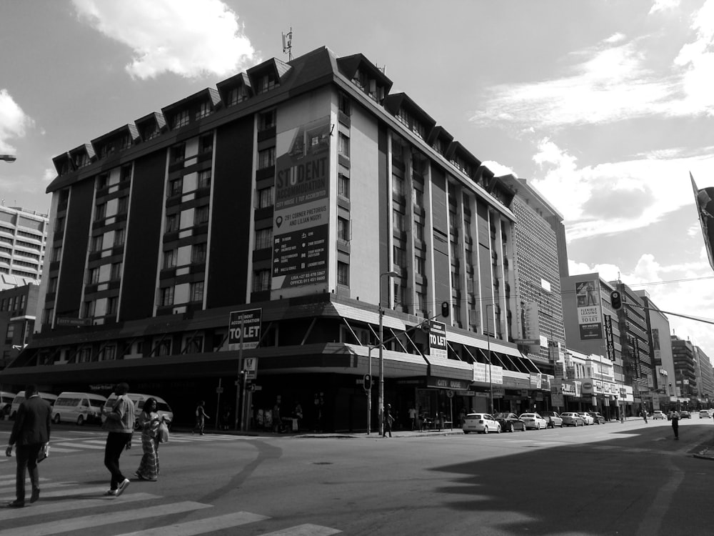 a black and white photo of people crossing the street