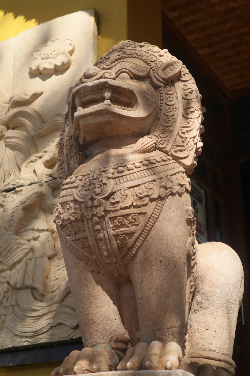 a stone statue of a lion on display in front of a building
