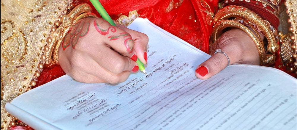 a woman in a red dress writing on a piece of paper