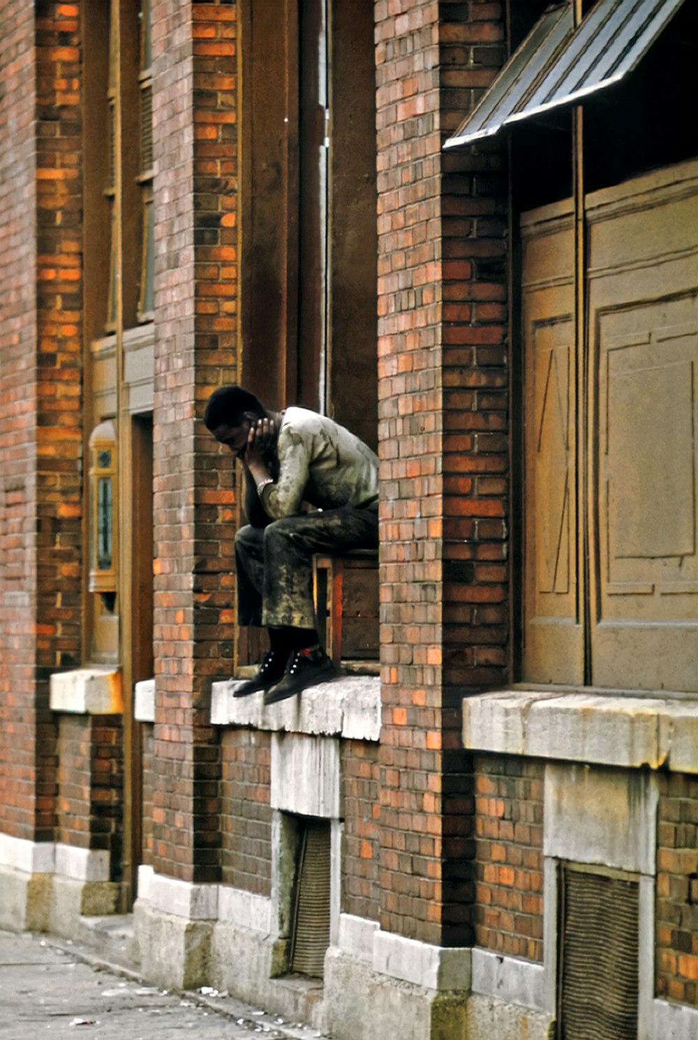 a man sitting on the ledge of a building