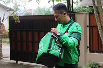a man in a green jacket carrying a green bag