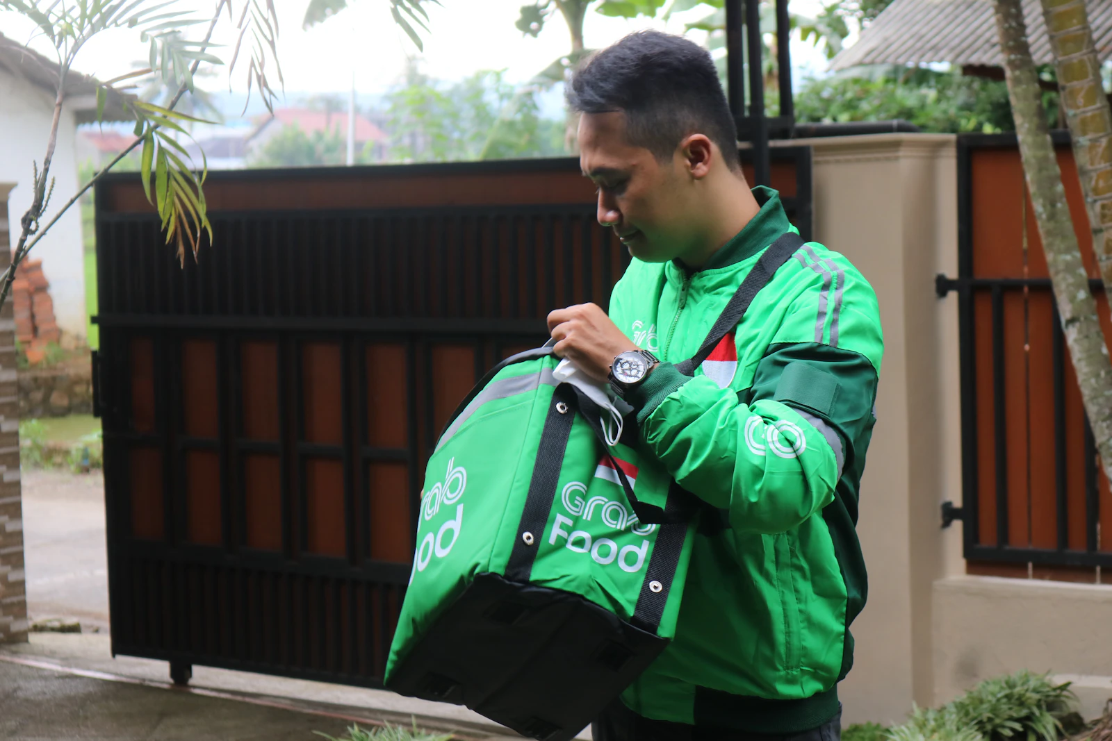 DHOBI & CO valet carrying a delivery bag