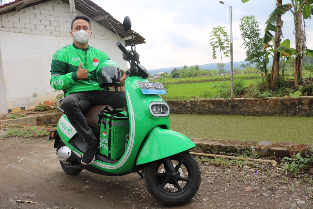 a man in a green jacket is sitting on a green scooter
