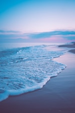 Calm waves gently rolling on a serene beach at sunrise symbolizing flow and balance.