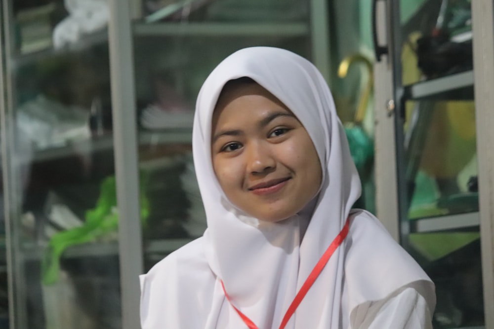 uma jovem mulher vestindo um hijab branco e sorrindo