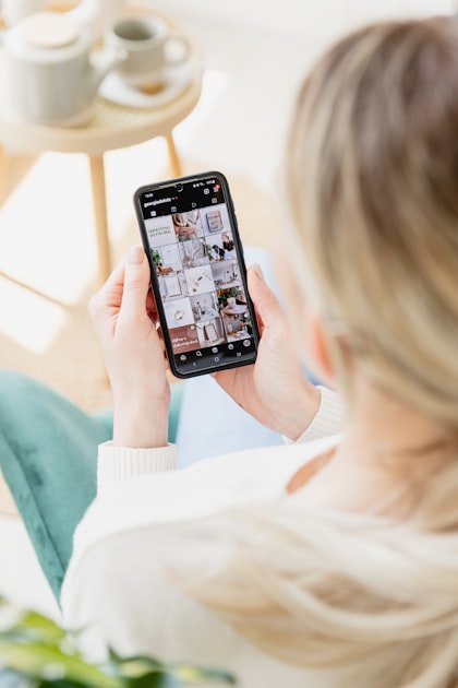 Hand holding a smartphone with Instagram open on the screen