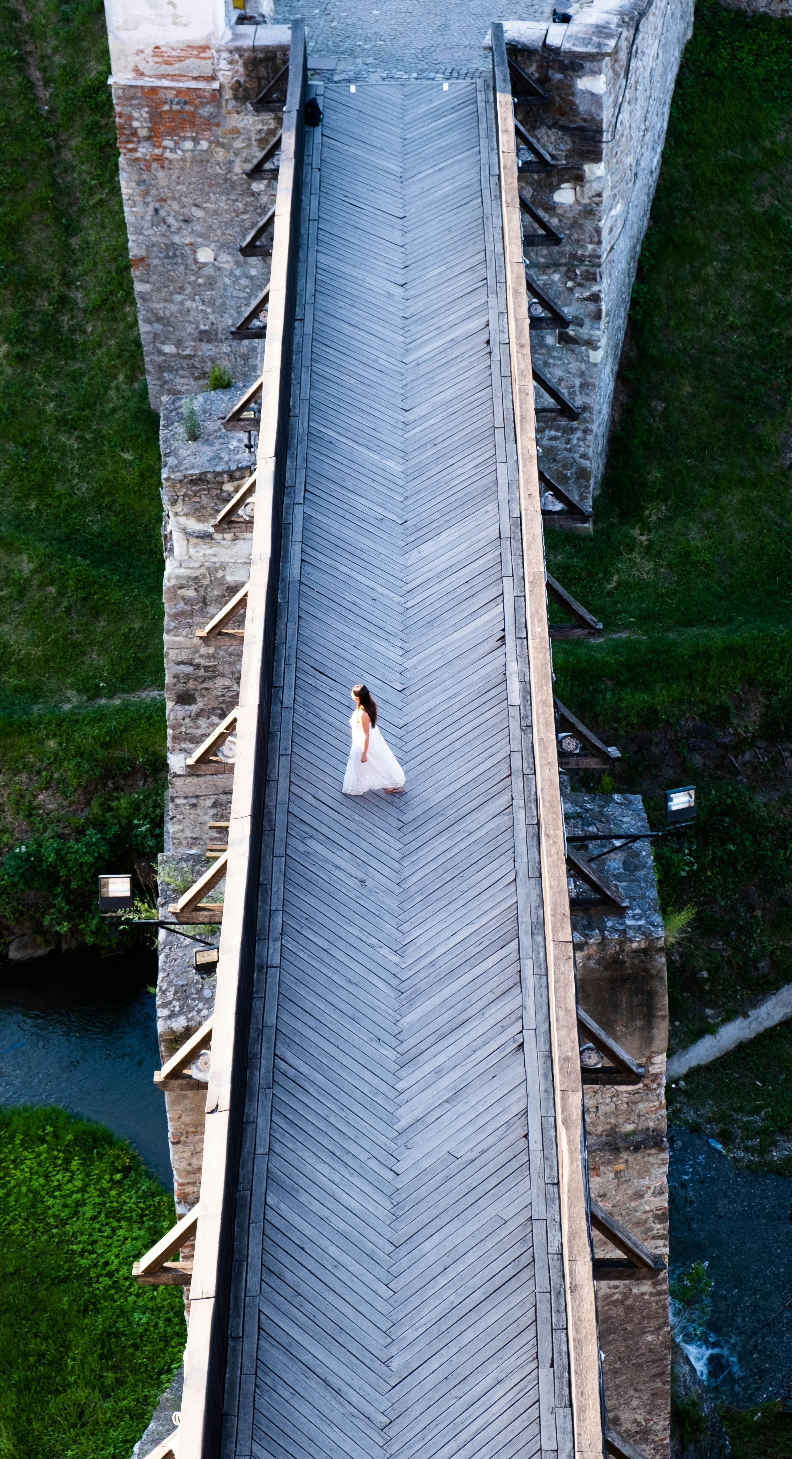 Una mujer con un vestido blanco parada en un puente