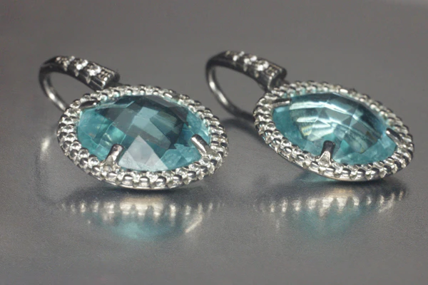 Silver earrings with faceted aqua stones framed by small crystals