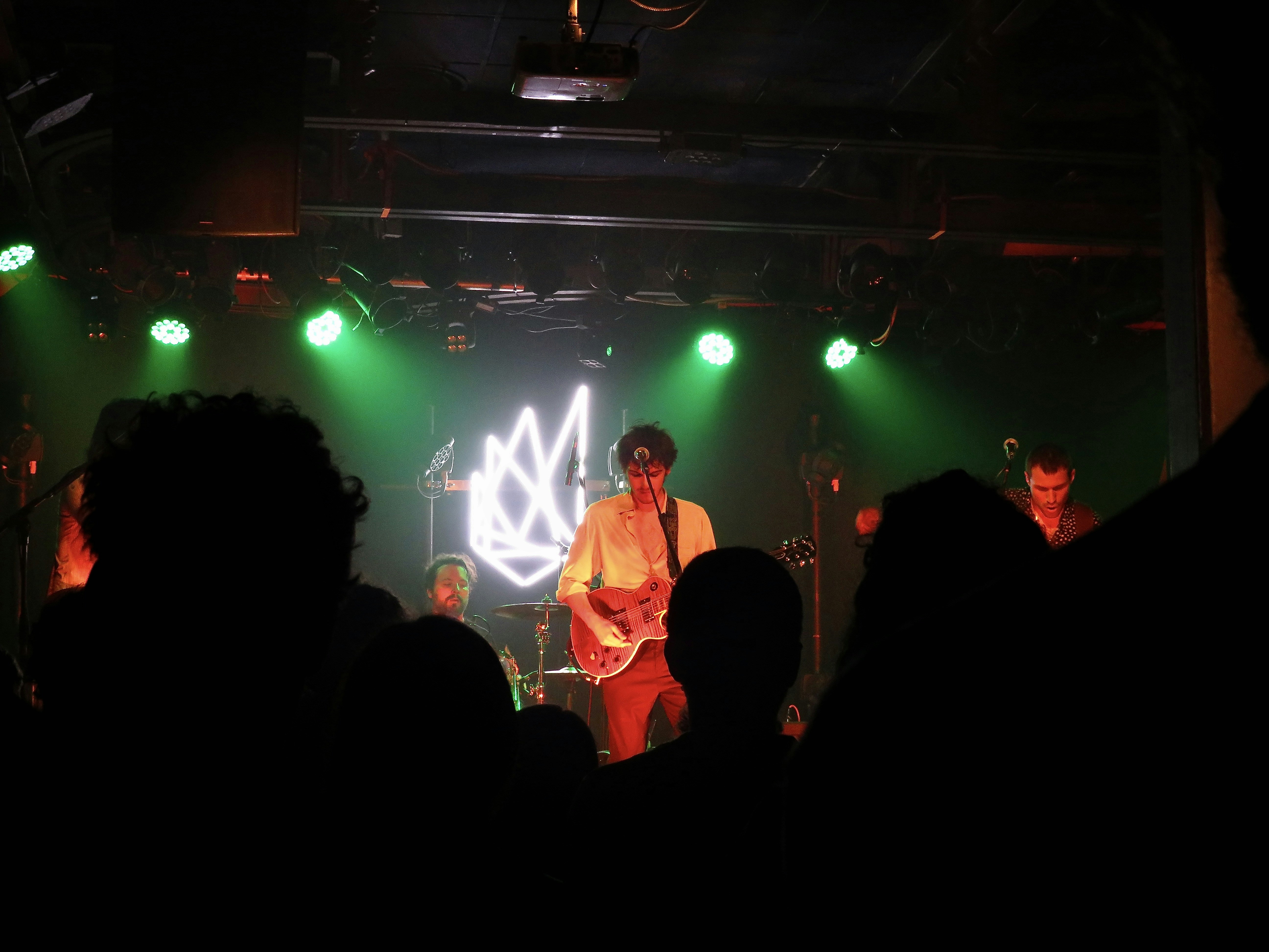 a man standing on a stage with a guitar