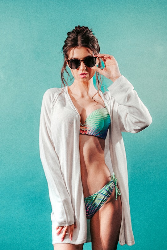 a woman in a bikini and cardigan posing for a picture