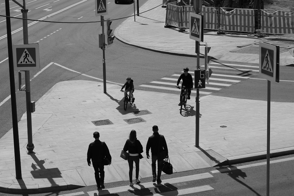 a group of people walking down a street next to a traffic light