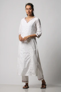 A proud customer posing in a classic white dhoti and shirt, embodying timeless South Indian style.