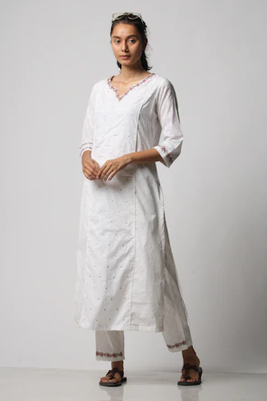 Model wearing a custom embroidered kurta in a bright outdoor setting.