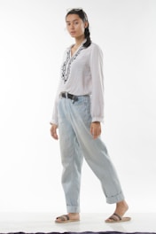 a woman in a white shirt and blue jeans