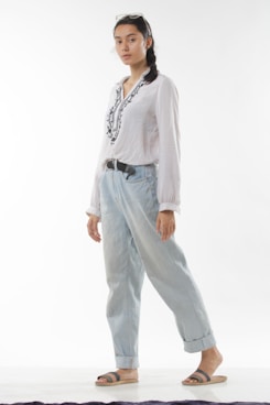 a woman in a white shirt and blue jeans