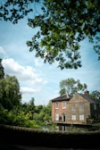 a large brick building sitting next to a lush green forest
