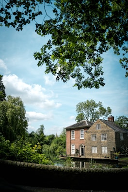 a large brick building sitting next to a lush green forest
