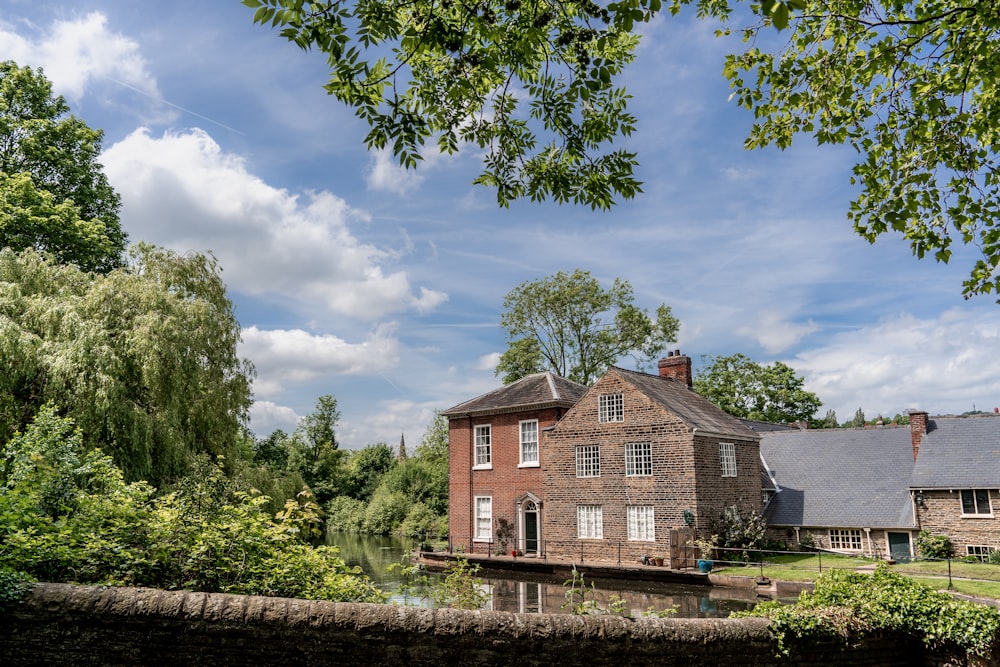 a large brick house sitting next to a river
