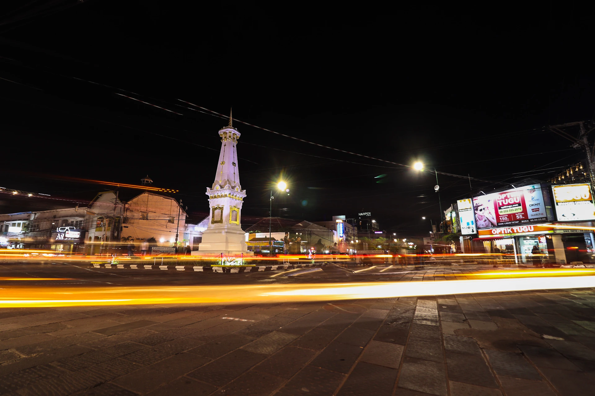 a city street at night with a clock tower in the background