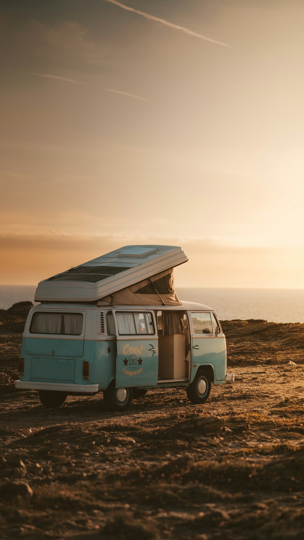 uma van azul e branca com uma prancha de surf em cima dela