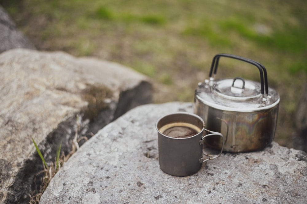 a cup of coffee sitting on top of a rock