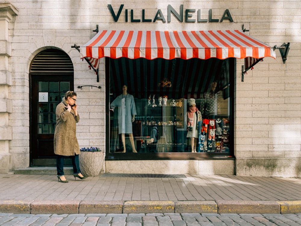 a woman talking on a cell phone in front of a store