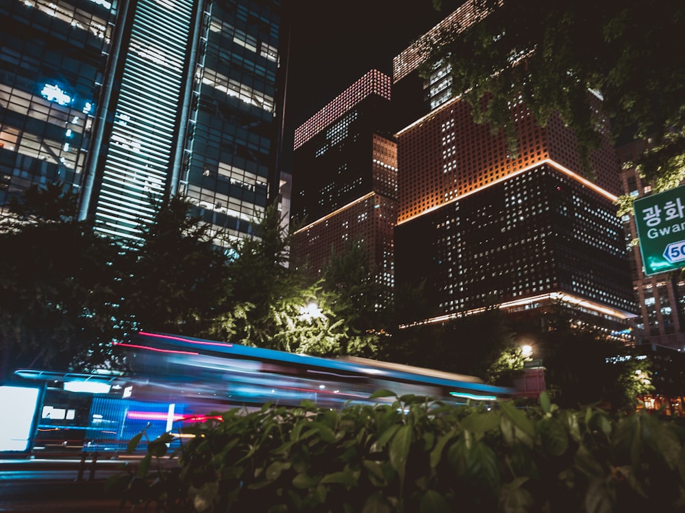 a city street at night with a bus passing by