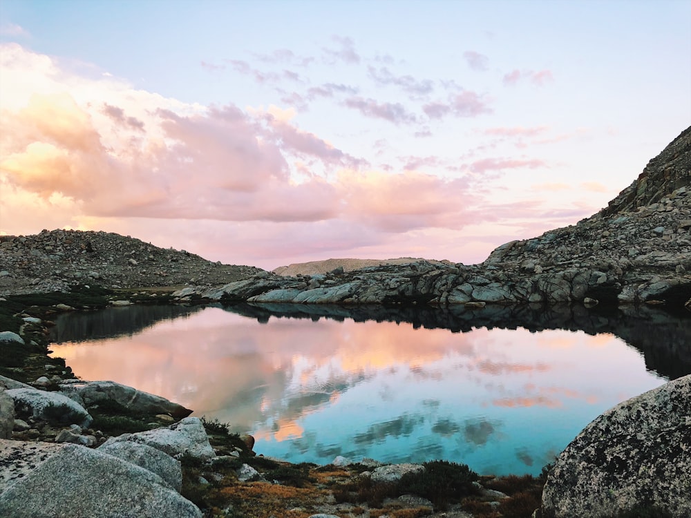 Un lago circondato da rocce e una montagna