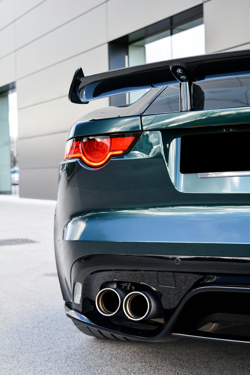 the rear end of a car parked in front of a building