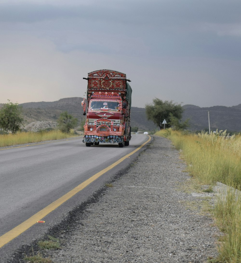 a red truck driving down a rural road