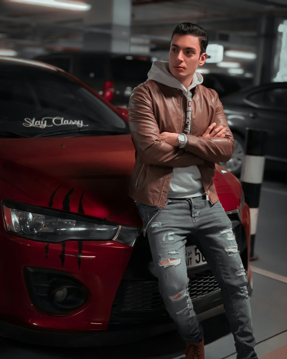 a man standing next to a red car