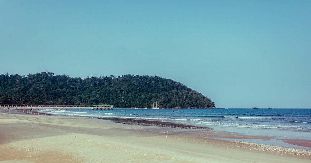 a sandy beach with a small island in the distance