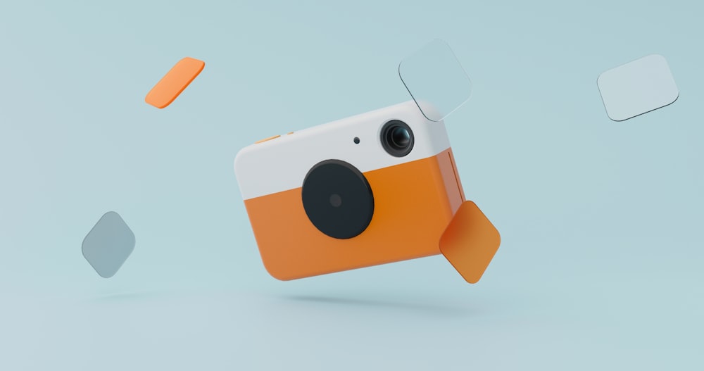 an orange and white camera with a pair of glasses on it
